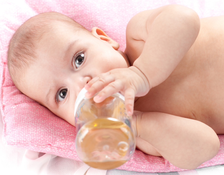 3 months adorable  baby girl drinking from plastic bottle in her bed