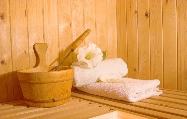 Sauna with towels, bucket and ladle and tropical flower just waiting for occupant